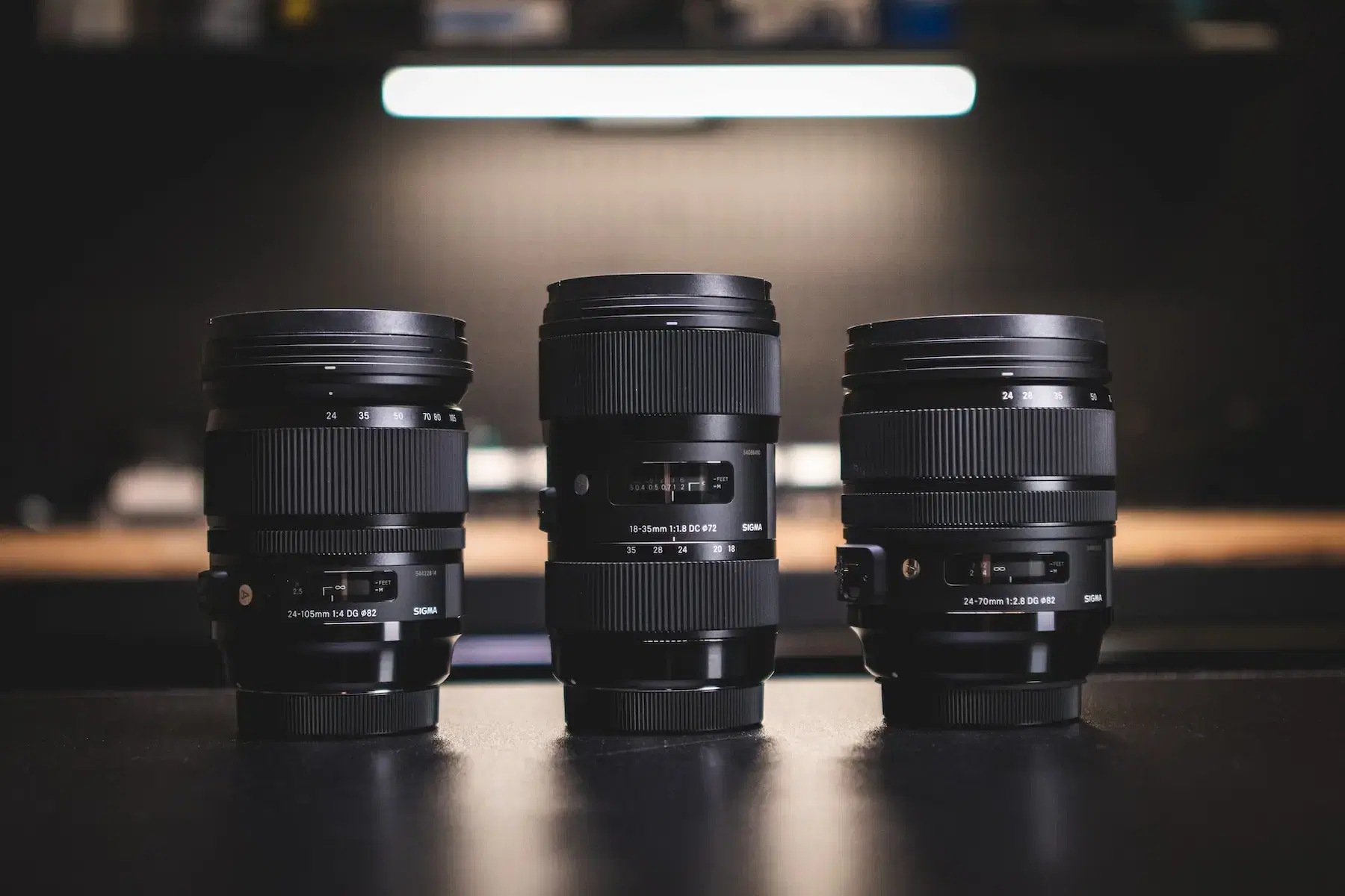 three camera lenses displayed on a table